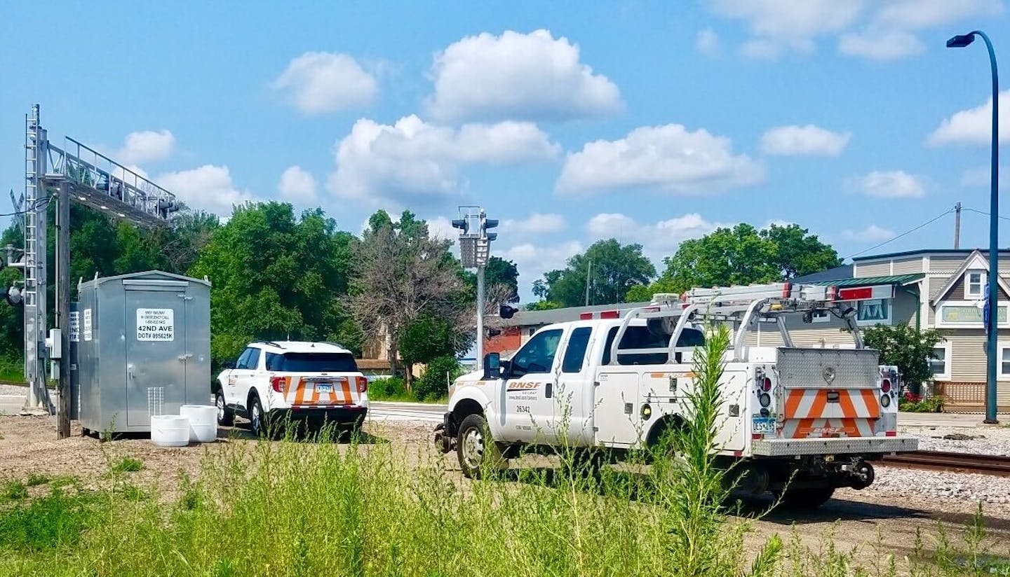 Rail personnel investigate Monday at scene where AN SUV was hit.