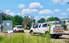 Rail personnel investigate Monday at scene where AN SUV was hit.