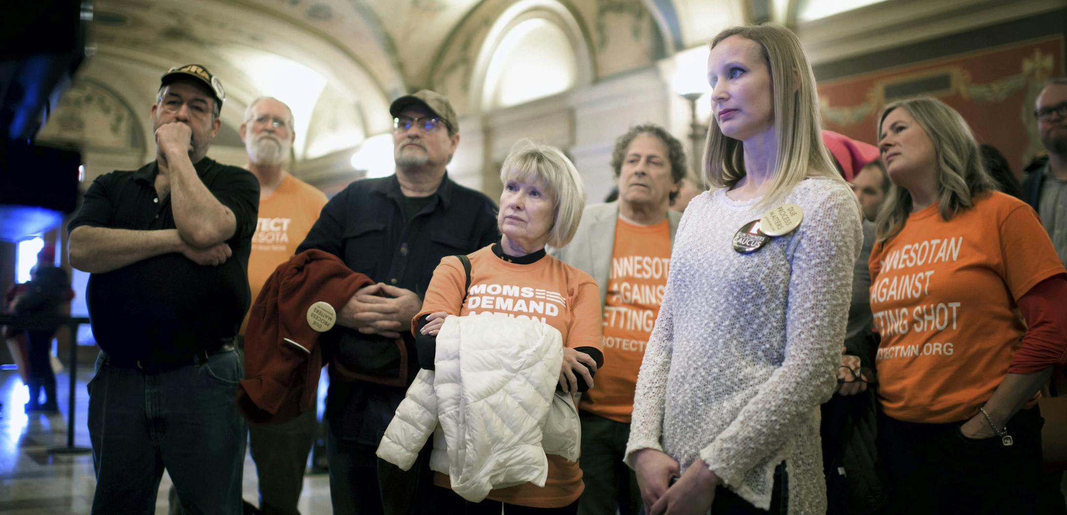 Advocates on both sides of the gun rights issue watch the debate on television screens in the hallway outside the hearing room at the Capitol, Thursday, March 1, 2018 in St. Paul, Minn. A Democratic move to force a hearing on two bills aimed at gun violence ended in defeat Thursday, with Republicans who control a House committee tabling the bills despite a heavy turnout from supporters, including one student who said she has nightmares her school will be attacked. (Glen Stubbe/Star Tribune via A