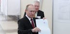 Incumbent Russian President Vladimir Putin, front, votes at a polling station in Moscow, Russia, on Sunday, March 18, 2018. The Central Election Commi