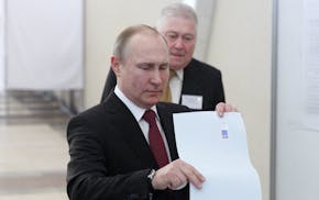 Incumbent Russian President Vladimir Putin, front, votes at a polling station in Moscow, Russia, on Sunday, March 18, 2018. The Central Election Commi