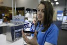 A salesperson demonstrates the selfie features on the new Samsung Galaxy S6 smartphone that went on sale Friday, April 10, 2015, at a Best Buy electro