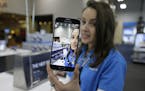 A salesperson demonstrates the selfie features on the new Samsung Galaxy S6 smartphone that went on sale Friday, April 10, 2015, at a Best Buy electro