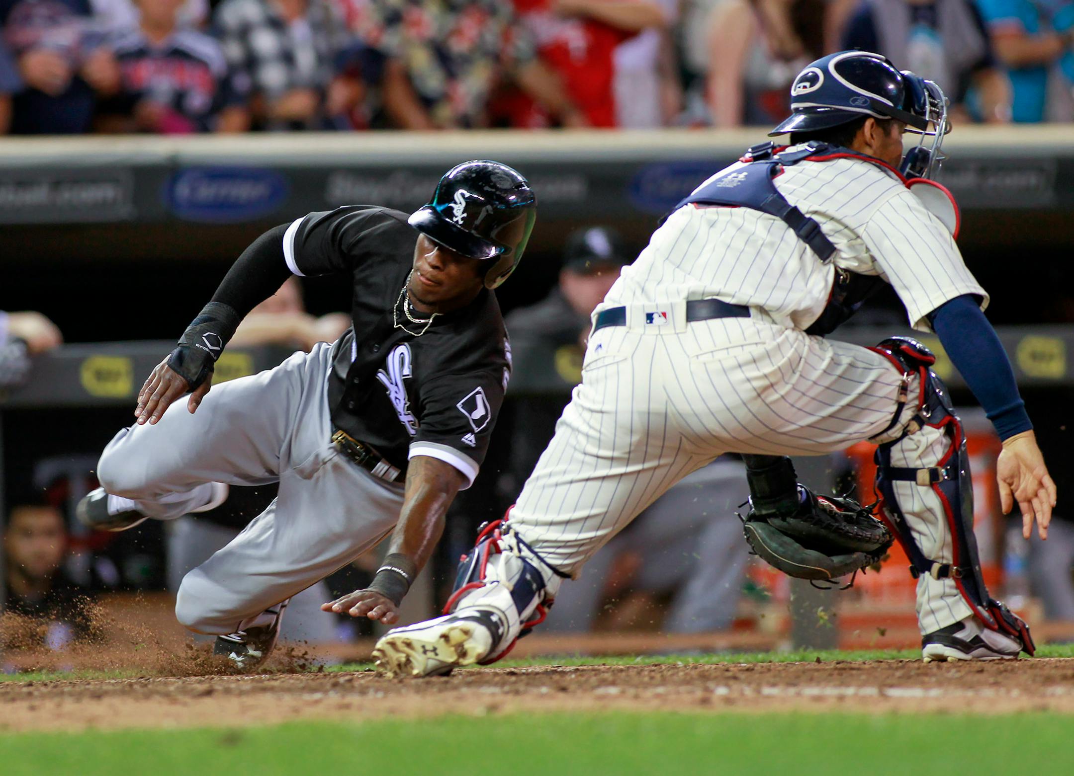 Chicago White Sox's Tim Anderson, left, scores from second on a Melky Cabrera single as Minnesota Twins catcher Kurt Suzuki, right, waits for the throw during the ninth inning of an baseball game, Saturday, July 30, 2016, in Minneapolis. (AP Photo/Paul Battaglia)