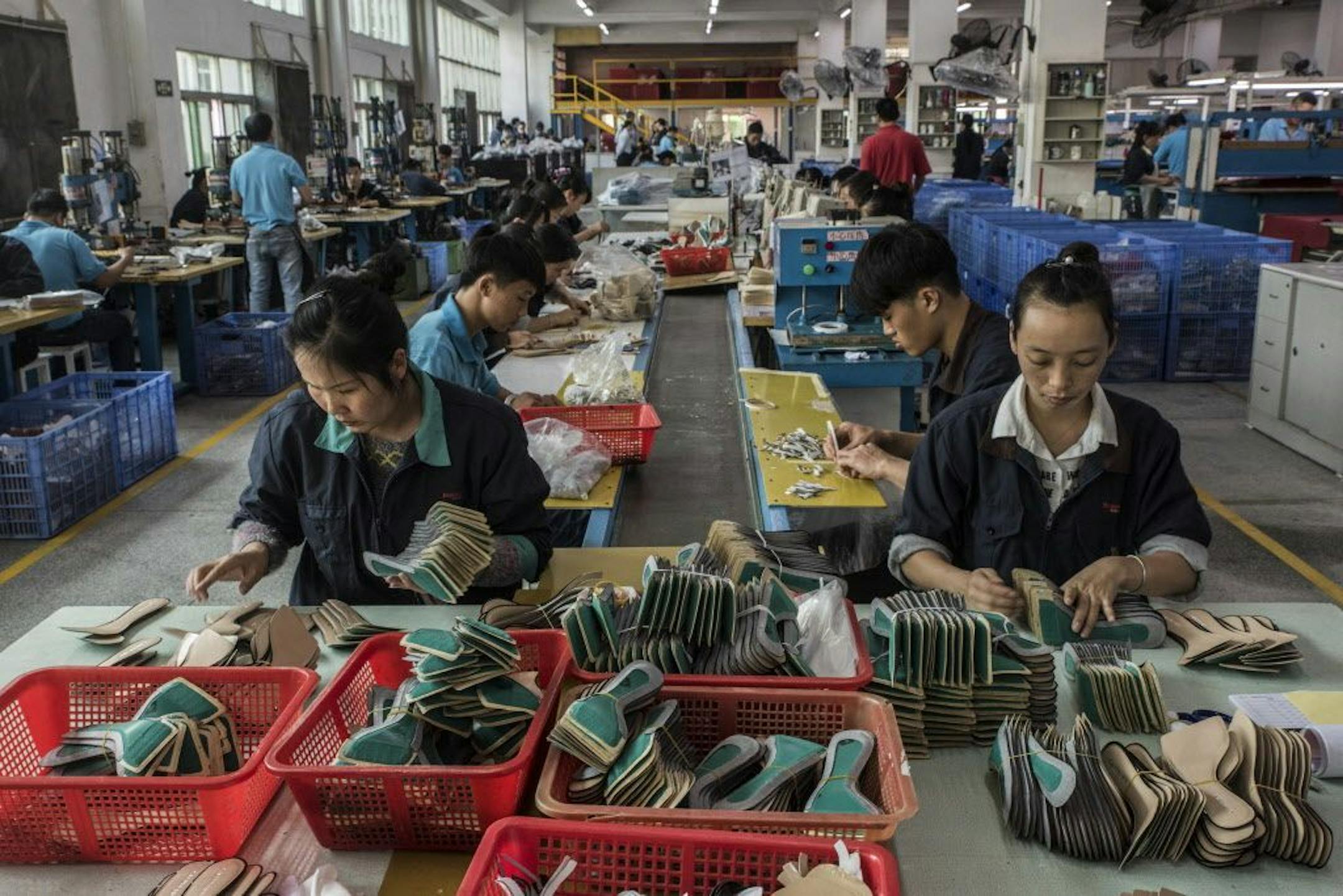 Workers on an assembly line at a Huajian International shoe factory, which makes shoes for Ivanka Trump and other designers, in Dongguan, China, Dec. 5, 2016. As workers at the factory and others in China complain of excessive hours and seek higher pay, the factory owner is sending more jobs to Africa where labor is cheaper.