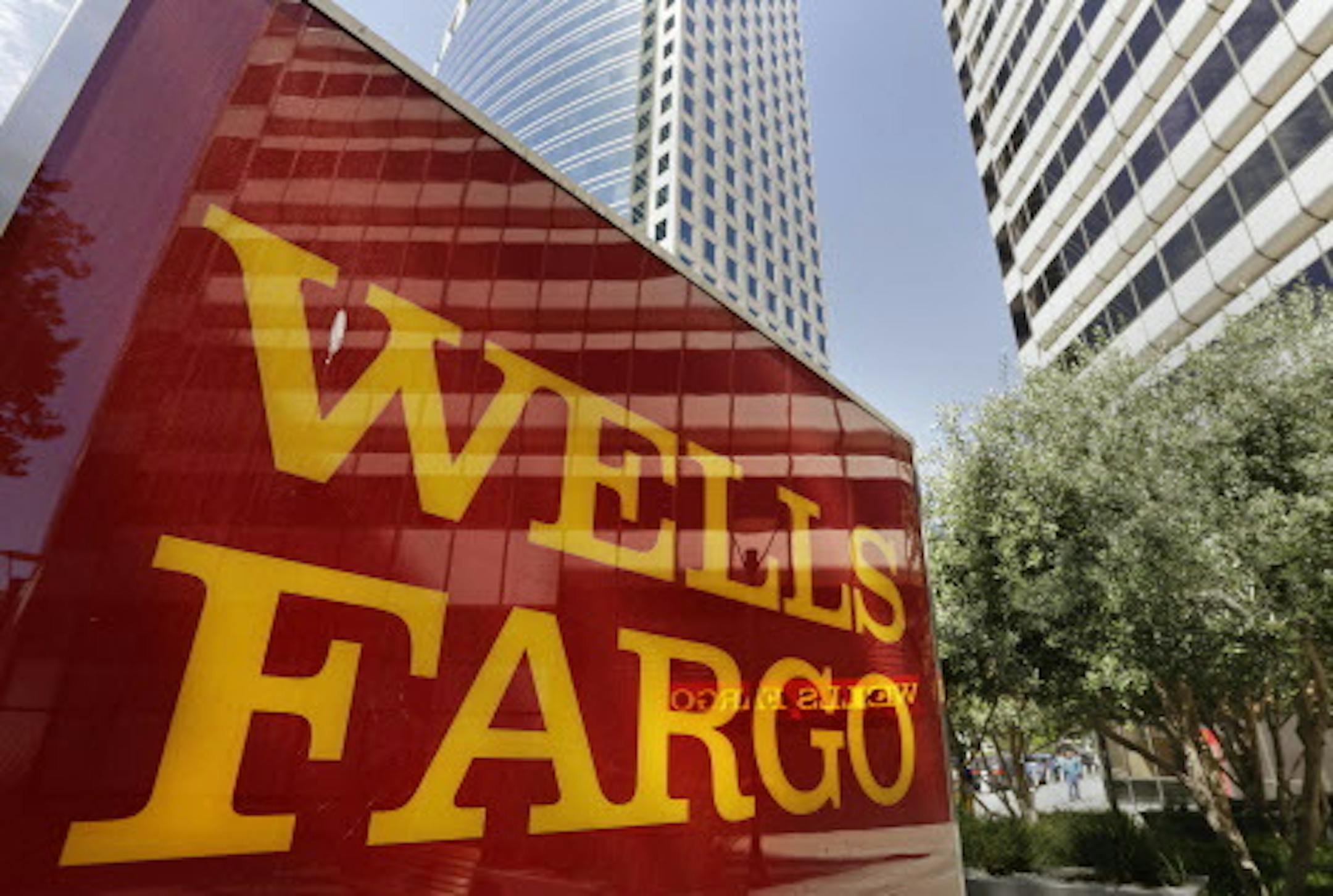 This July 14, 2014 photo shows Wells Fargo offices in Oakland, Calif. Wells Fargo reports quarterly earnings on Wednesday, Jan. 14, 2015. (AP Photo/Ben Margot)