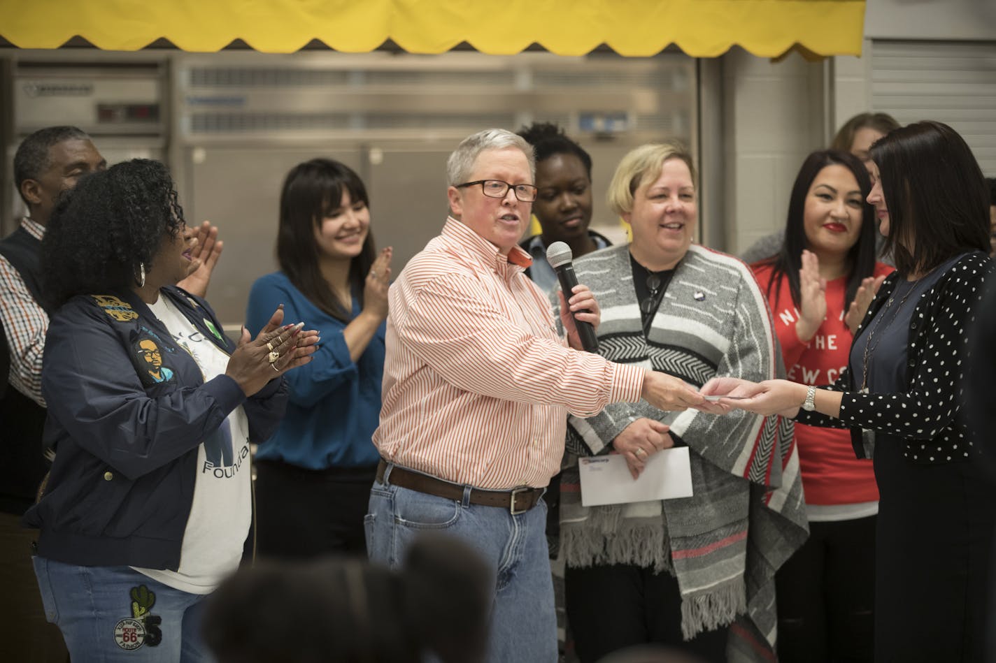 Metro State teacher Pam Fergus presented director of nutrition services Stacy Koppen a check for $10,000, only part of what has been fundraised by the "Philando Feeds the Children" effort, during an event at J.J. Hill Montessori in St. Paul, Minn., on Friday, October 13, 2017.