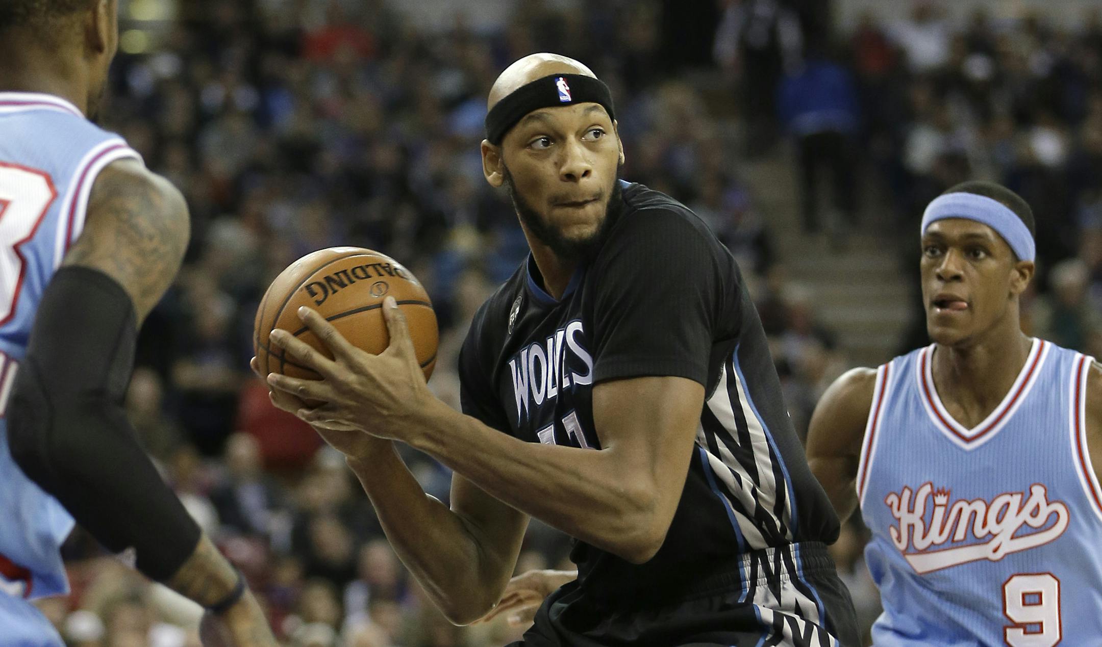 Minnesota Timberwolves forward Adreian Payne, center, looks to pass between Sacramento Kings' Ben McLemore, left, and Rajon Rondo, right, during the first quarter of an NBA basketball game in Sacramento, Calif., Friday, Nov. 27, 2015.(AP Photo/Rich Pedroncelli)