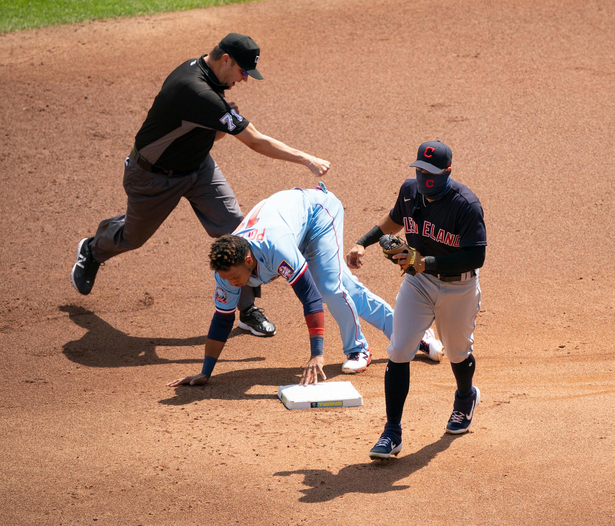 Umpire Jordan Baker (71) signaled that Minnesota Twins shortstop Jorge Polanco (11) was out stealing second in the first inning after Cleveland Indians second baseman Cesar Hernandez (7) made the tag.