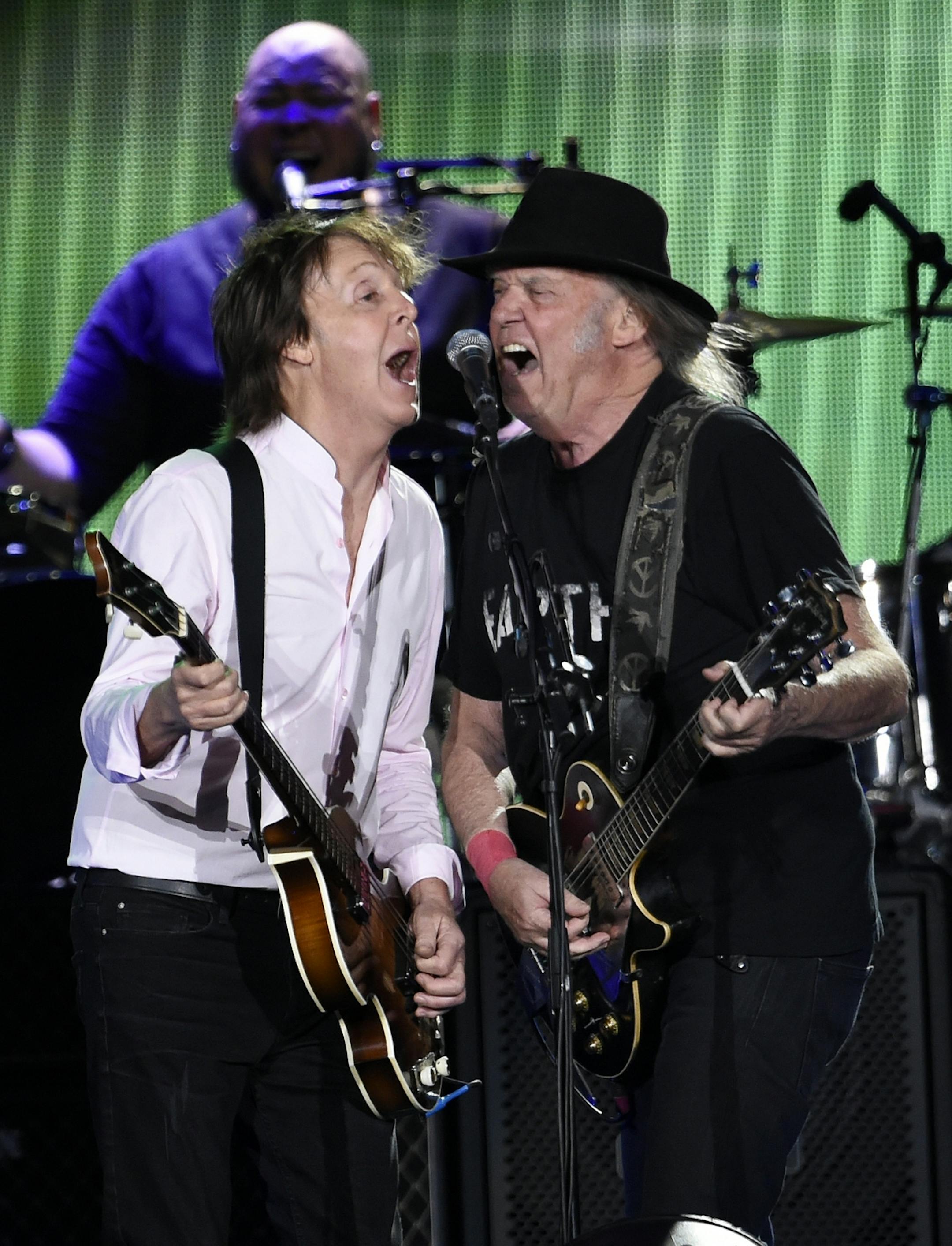 Paul McCartney, left, is joined at the microphone by Neil Young during his performance on day 2 of the 2016 Desert Trip music festival at Empire Polo Field on Saturday, Oct. 8, 2016, in Indio, Calif.
