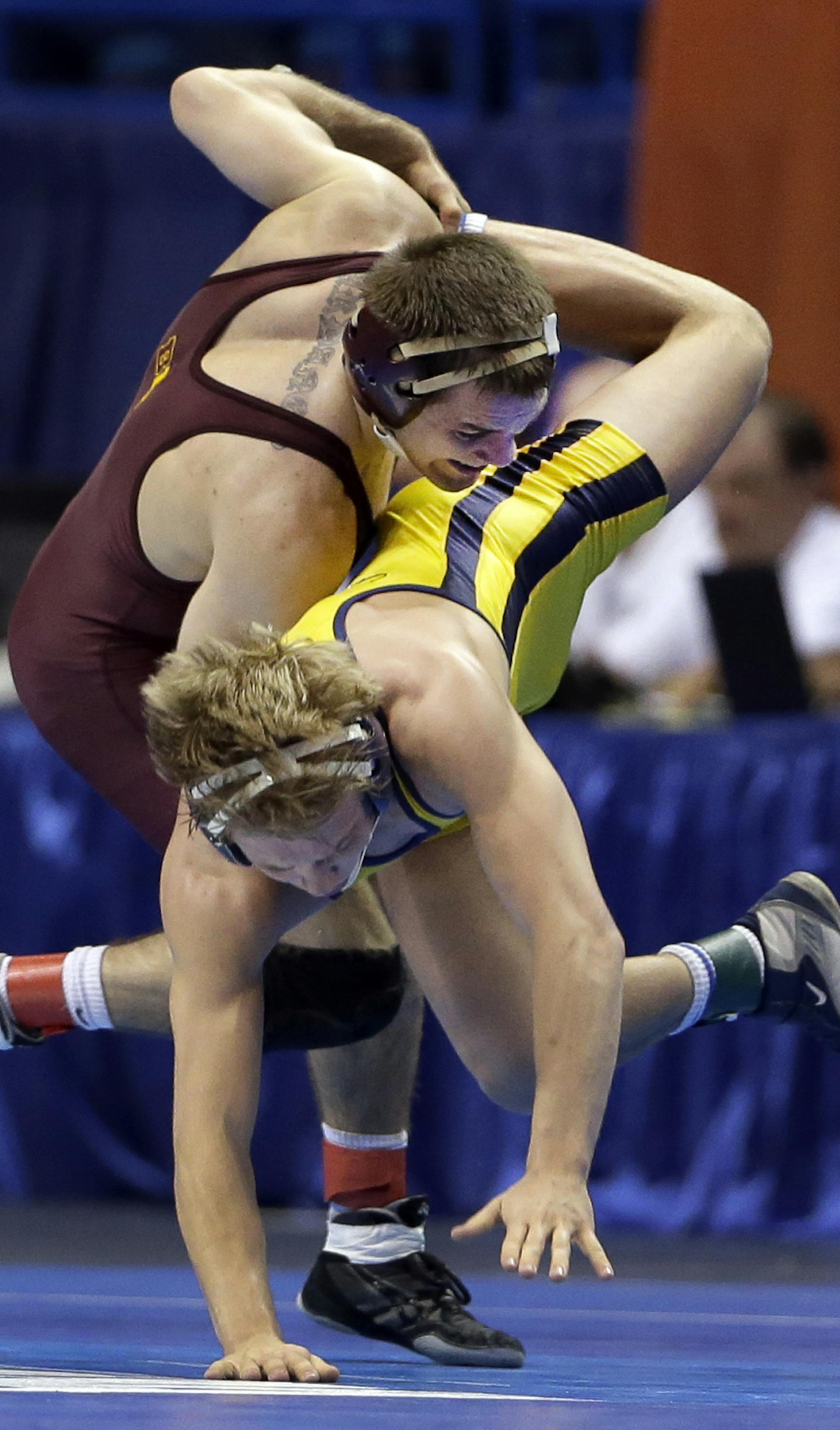 Minnesota’s Christopher Dardanes, top, wrestles with Kent State's Mackenzie McGuire during their 133-pound second-round match Thursday, March 19, 2015, at the NCAA Division I Wrestling Championships in St. Louis. (AP Photo/Jeff Roberson)
