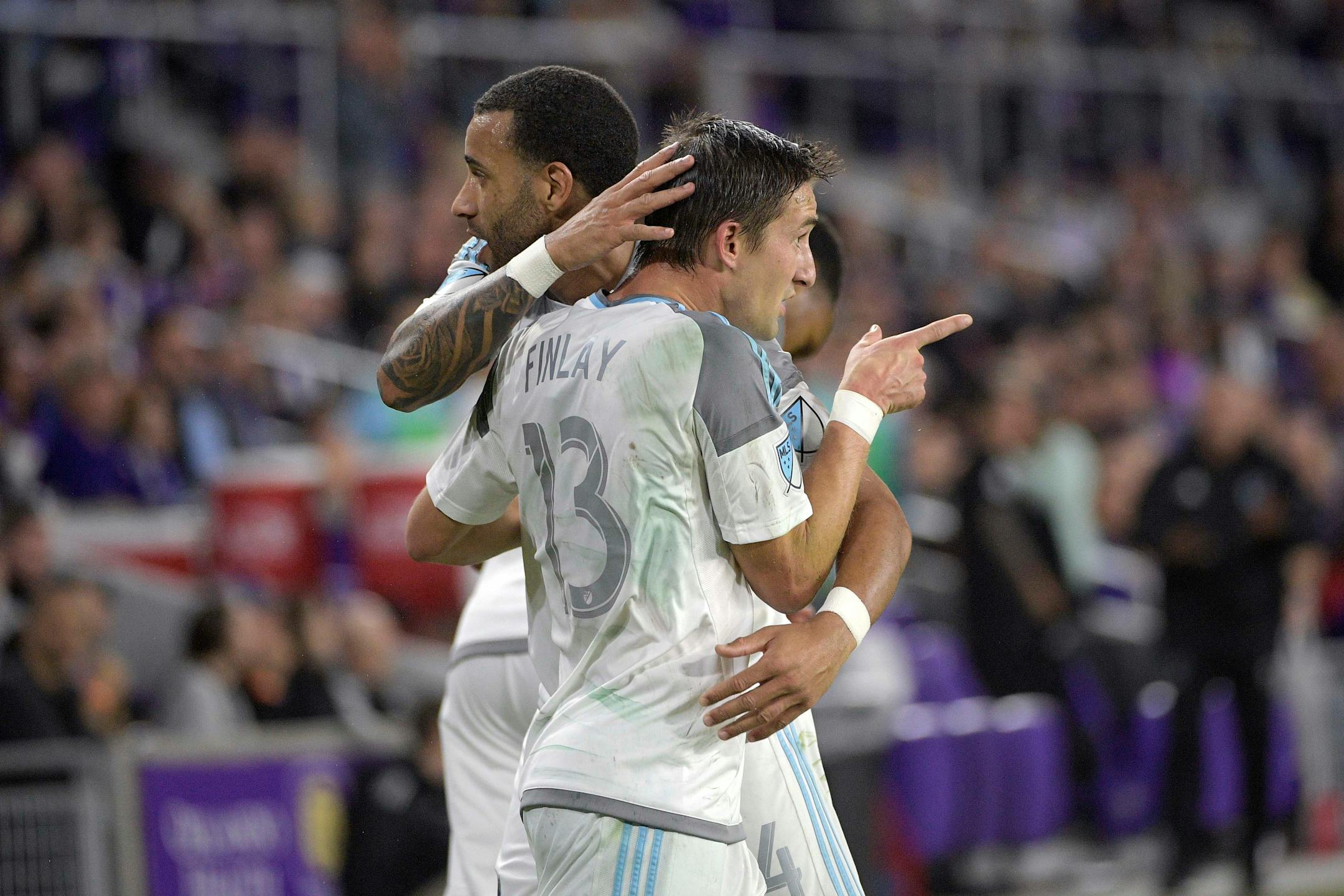 Minnesota United midfielder Ethan Finlay (13) is congratulated by defender Tyrone Mears (4) after scoring a goal during the second half of an MLS soccer match against Orlando City Saturday, March 10, 2018, in Orlando, Fla. Minnesota won 2-1. (Phelan M. Ebenhack for the Star-Tribune) ORG XMIT: OTKMINN110