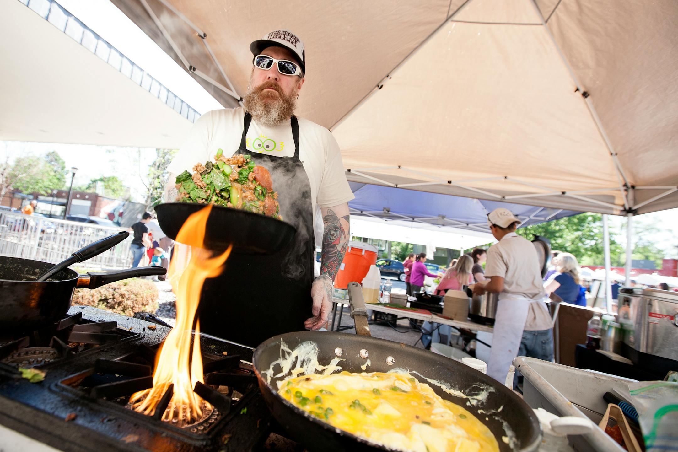 Cook David Anderson works the stove at Gai Gai Thai at the Kingfield Farmers Market June 8, 2014. (Courtney Perry/Special to the Star Tribune)