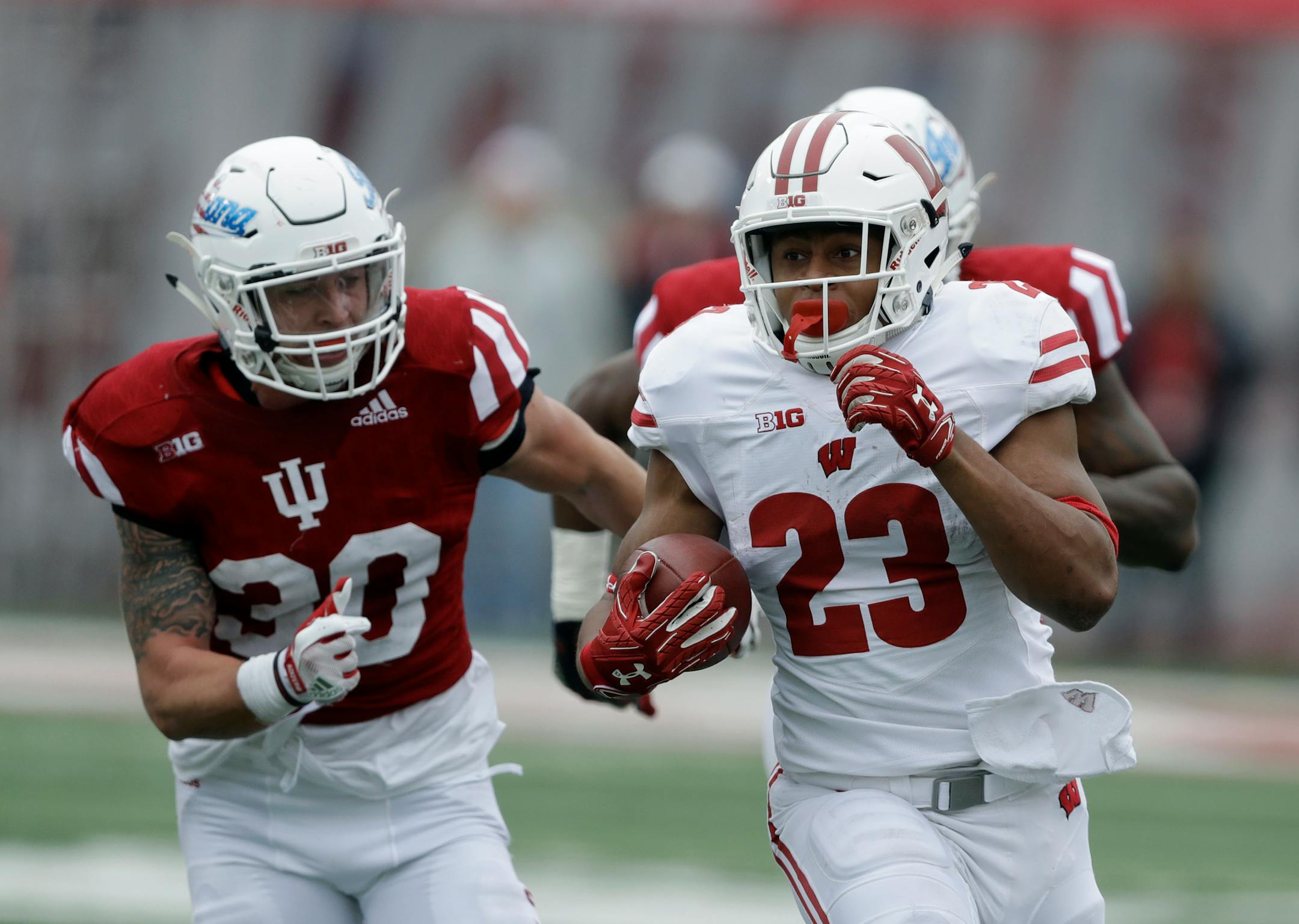 Wisconsin's Jonathan Taylor was chased by Indiana's Chase Dutra during the first half Saturday.