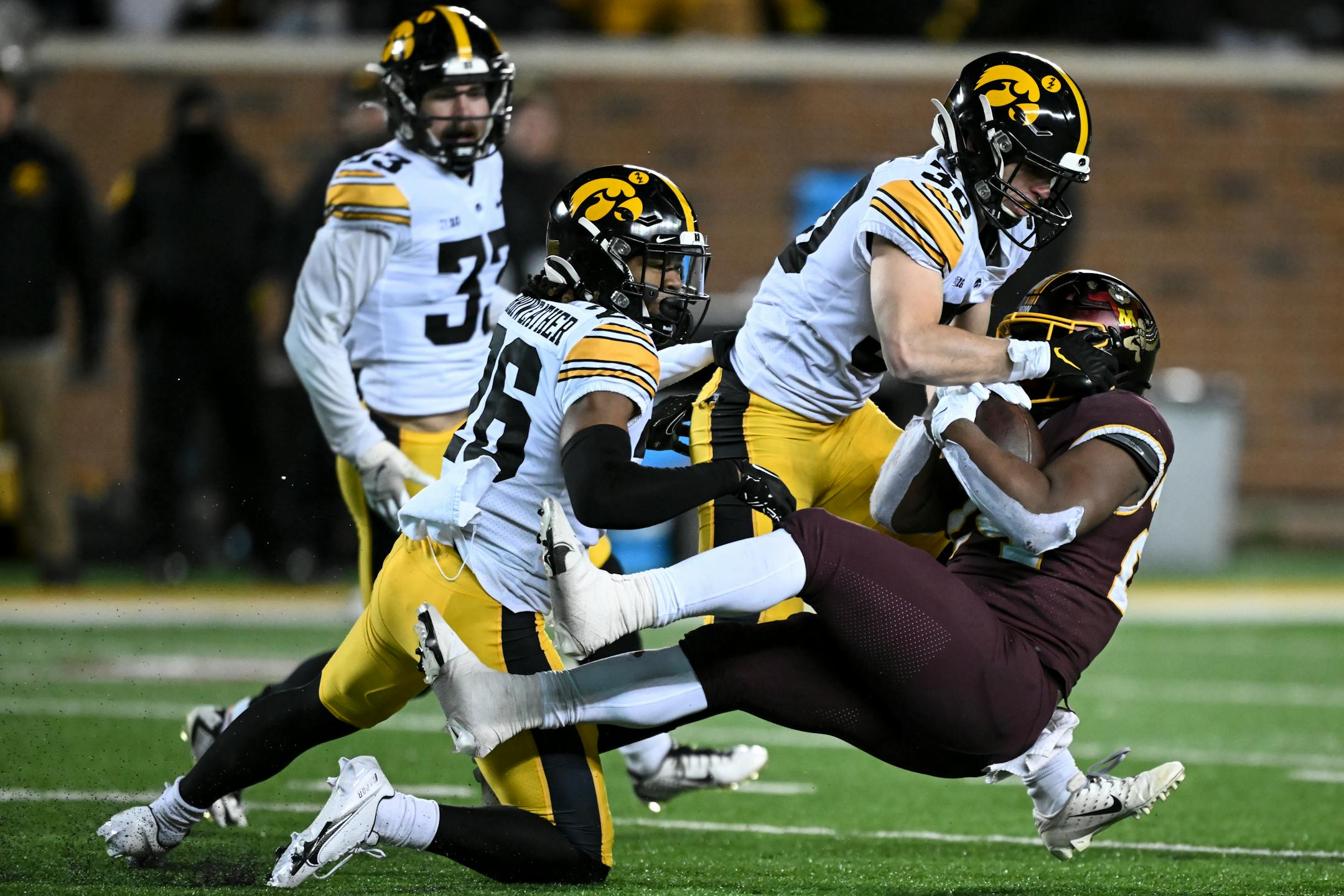 Minnesota Gophers running back Mohamed Ibrahim (24) is tackled by Iowa Hawkeyes defensive back Kaevon Merriweather (26) and defensive back Quinn Schulte (30) during the fourth quarter.