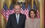 Senate Minority Leader Chuck Schumer of N.Y., and House Speaker Nancy Pelosi of Calif., pose for photographers after speaking on Capitol Hill in respo