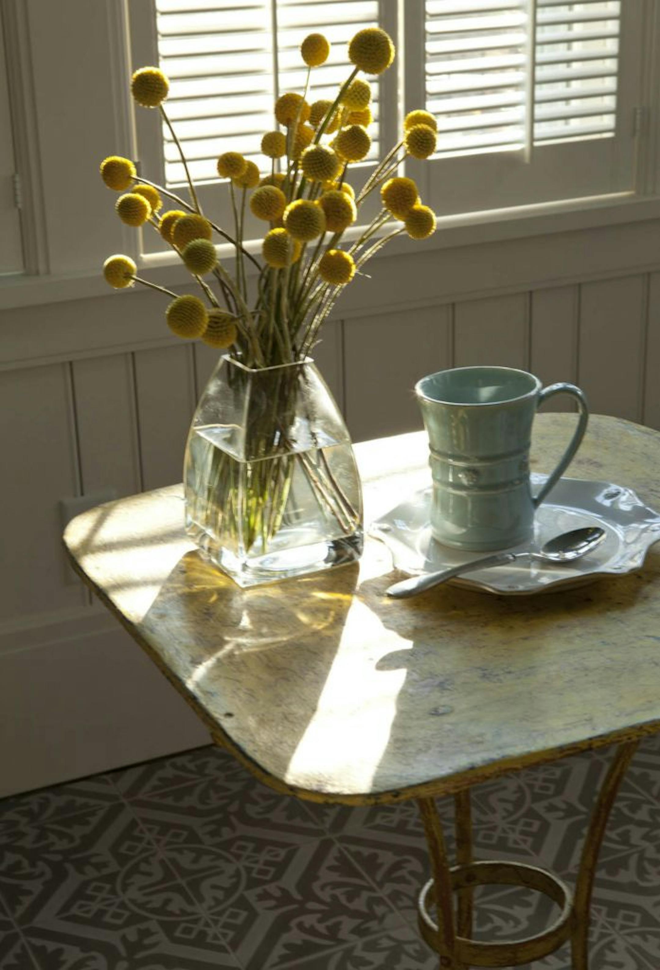 The patterned concrete tile on the floor and beadboard on the walls and ceilings add character to the bright sunroom.