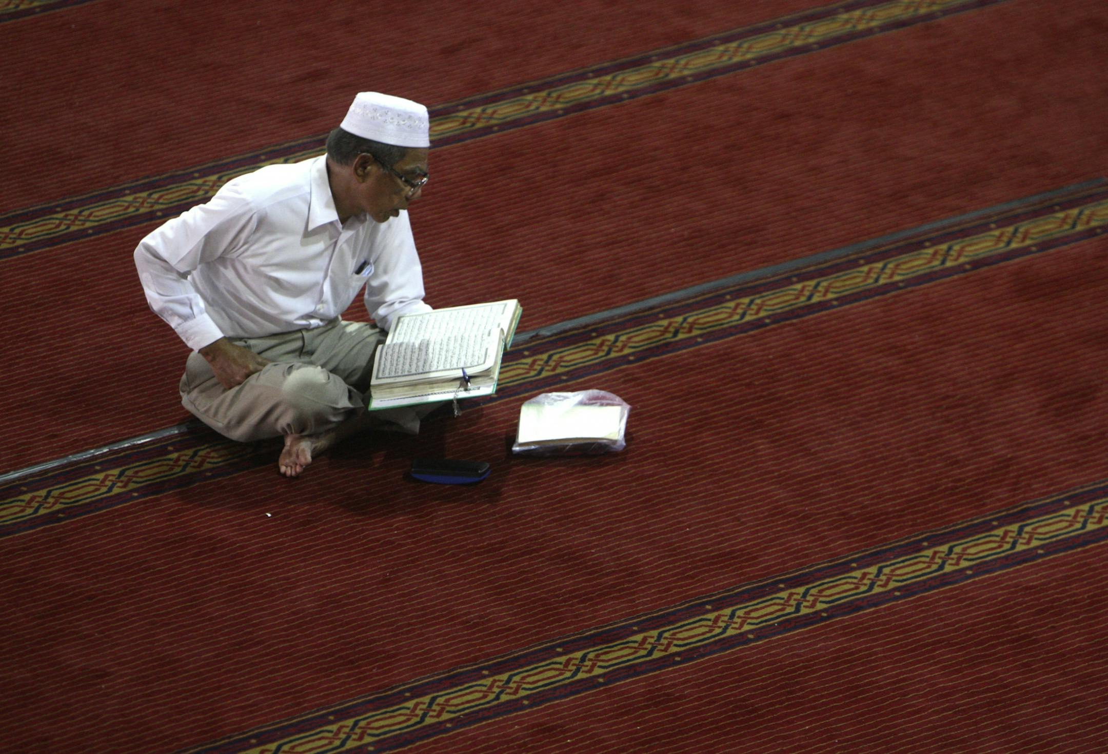 Photo: Muslim reading the Quran, the Islamic holy book.