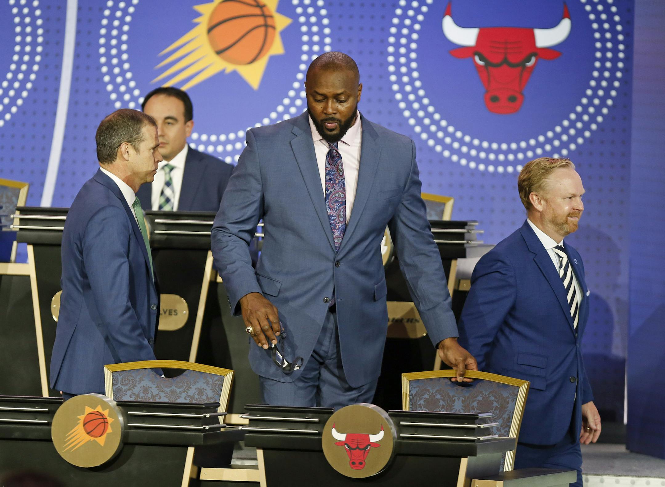 Former Chicago Bulls, player Horace Grant, center, and representatives from other teams take their seats prior to the NBA basketball draft lottery Tuesday, May 14, 2019, in Chicago. (AP Photo/Nuccio DiNuzzo)
