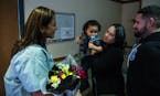 Registered nurse Claudia Lopez, left, reunites with Jacob Roman, 2, center, held by his mother, Vicelis Negron, as his father, Alexander Roman, looks 