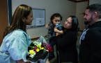 Registered nurse Claudia Lopez, left, reunites with Jacob Roman, 2, center, held by his mother, Vicelis Negron, as his father, Alexander Roman, looks 
