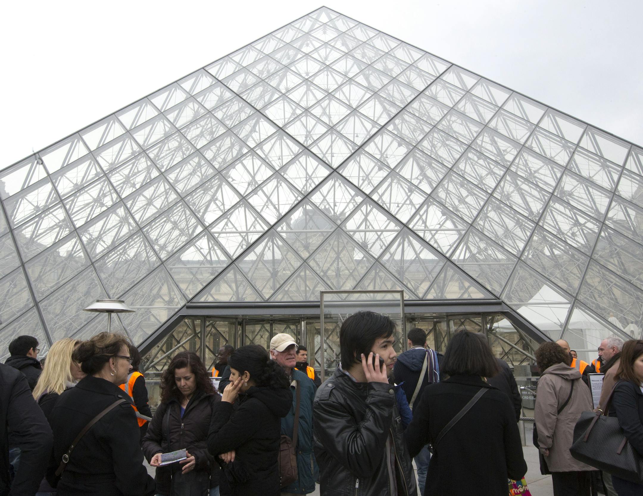 Visitors stands in front of to entrance in Louvre museum Paris, France, Wednesday, April 10, 2013. Paris' famed Louvre museum has been closed after workers walked off the job to protest what they say is the increasing problem of pickpockets at work in the museum's vast galleries. Louvre spokeswoman Sophie Grange was unable to say when the museum, which normally attracts up to 30,000 visitors a day at this time of year, would reopen. Museum staff organized the protest to draw attention to the pro