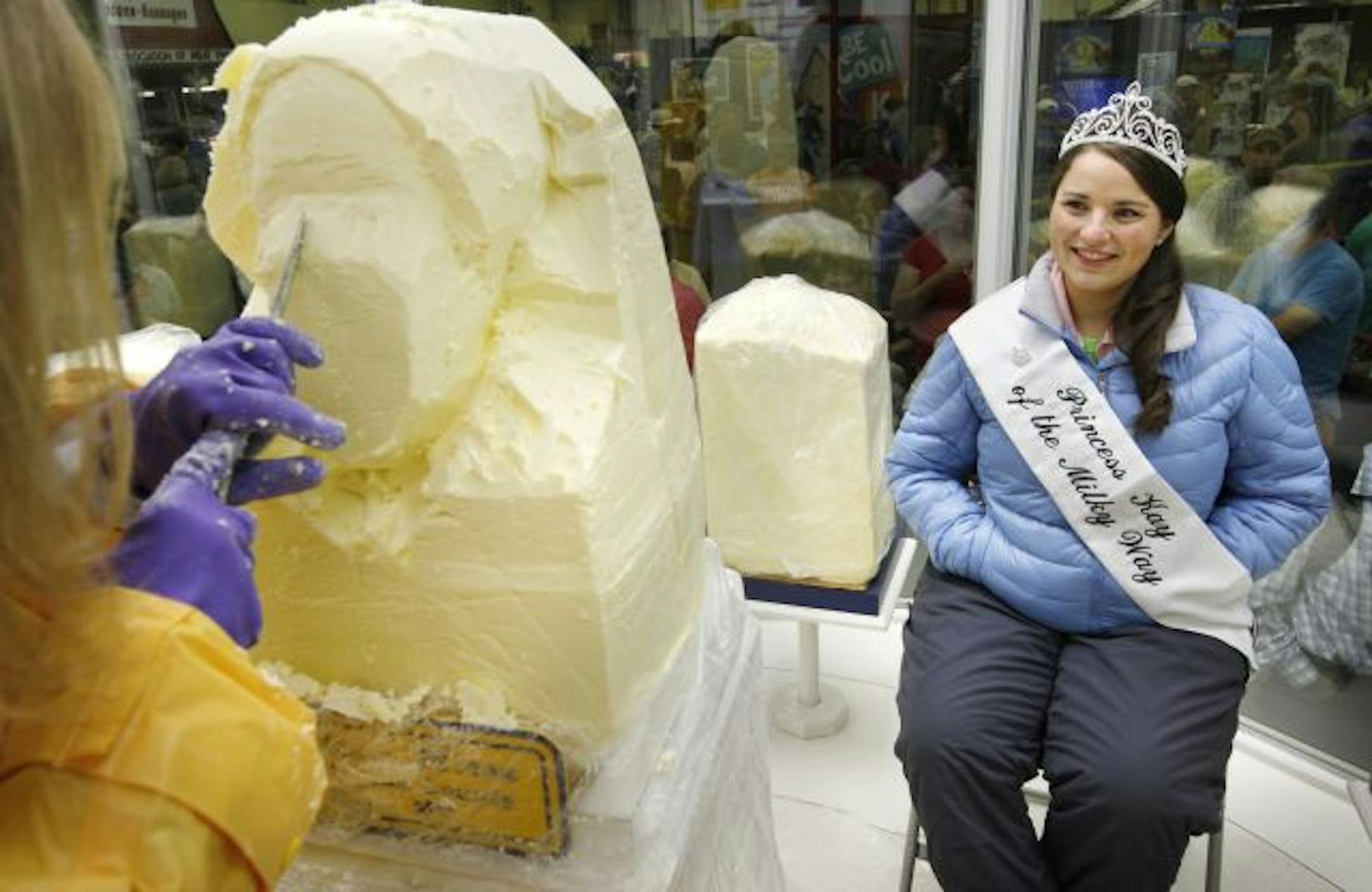 For her first official duty, the 57th Princess Kay of the Milkey Way, Katie Miron, of Hugo, sits in the chilled confines of the butter sculpting cooler to get her official butter head sculpted by Linda Christensen, who has been carving butter heads at the State Fair for 39 years. Katie, who comes from a dairy farm said she plans to have a corn feed in the fall and let the community share in the butter. "You wouldn't want it to go to waste" Katie said.
