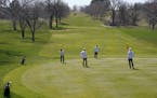 Golfers kept more than the recommended social distance from one another as they putted on the first hole Saturday at Columbia Golf Club.