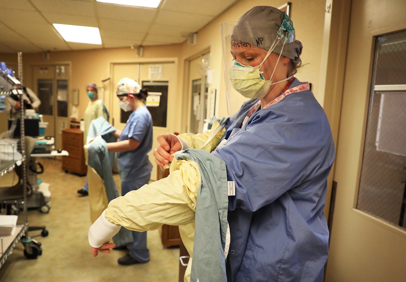 Healthcare workers don personal protective equipment ,including Kristen Benedict, CNP, front to back, Lesli White, RN, and Leah Chapman, RN in an ICU at Bethesda Hospital Thursday, May 7, 2020, in St. Paul, MN.] DAVID JOLES • david.joles@startribune.com Every time a COVID-19 patient leaves Bethesda Hospital alive, a bell rings throughout the St. Paul facility. Its a moral-booster for doctors and nurses -- as they struggle with a vexing disease, limited protective supplies, and the threat of many