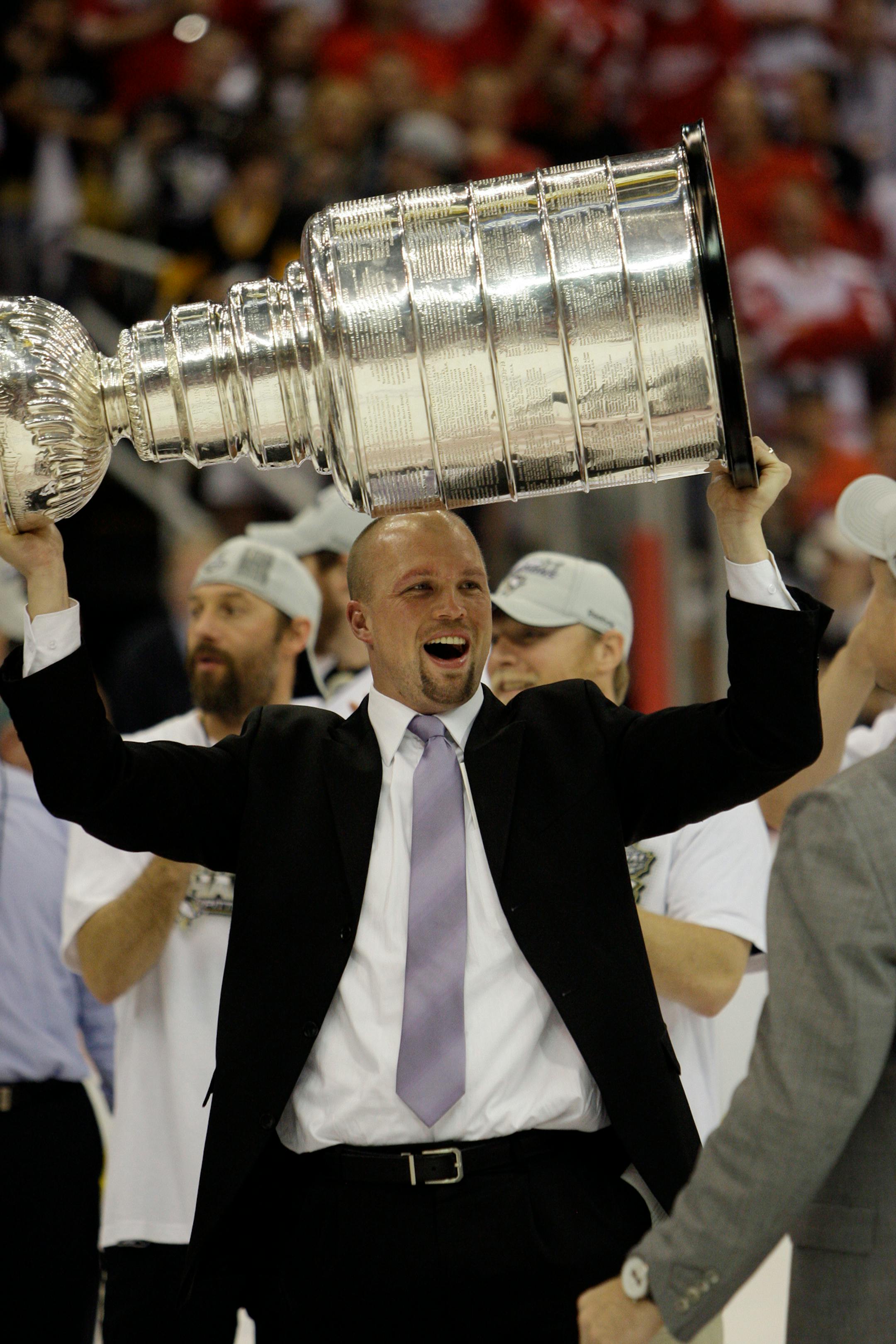 Pittsburgh Penguins assistant coach Mike Yeo raises the Stanley Cup after the Penguins beat the Detroit Red Wings 2-1 to win Game 7 of the NHL hockey Stanley Cup finals in Detroit, June 12, 2009. (AP Photo/Paul Sancya)