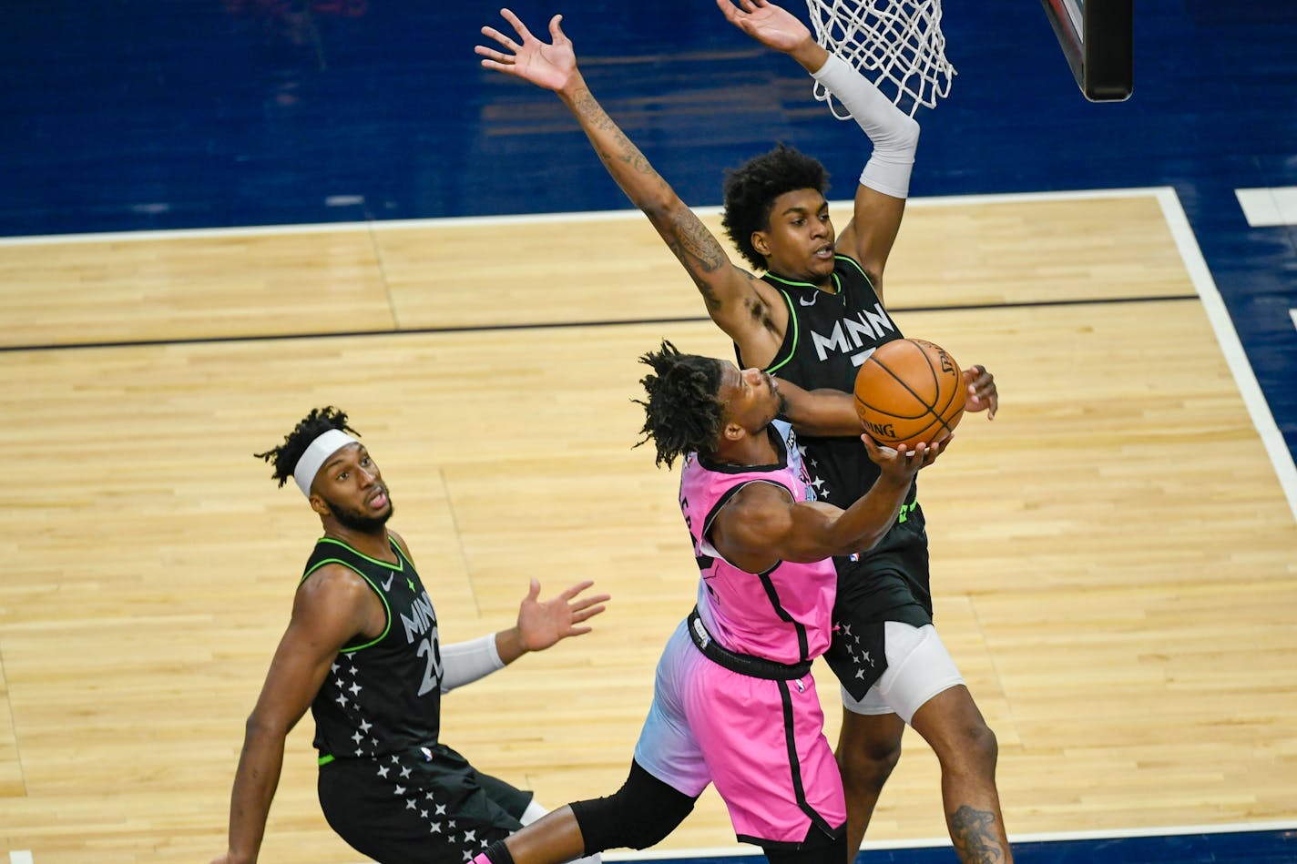 Miami forward Jimmy Butler goes up for a shot past Minnesota Timberwolves forward Jaden McDaniels