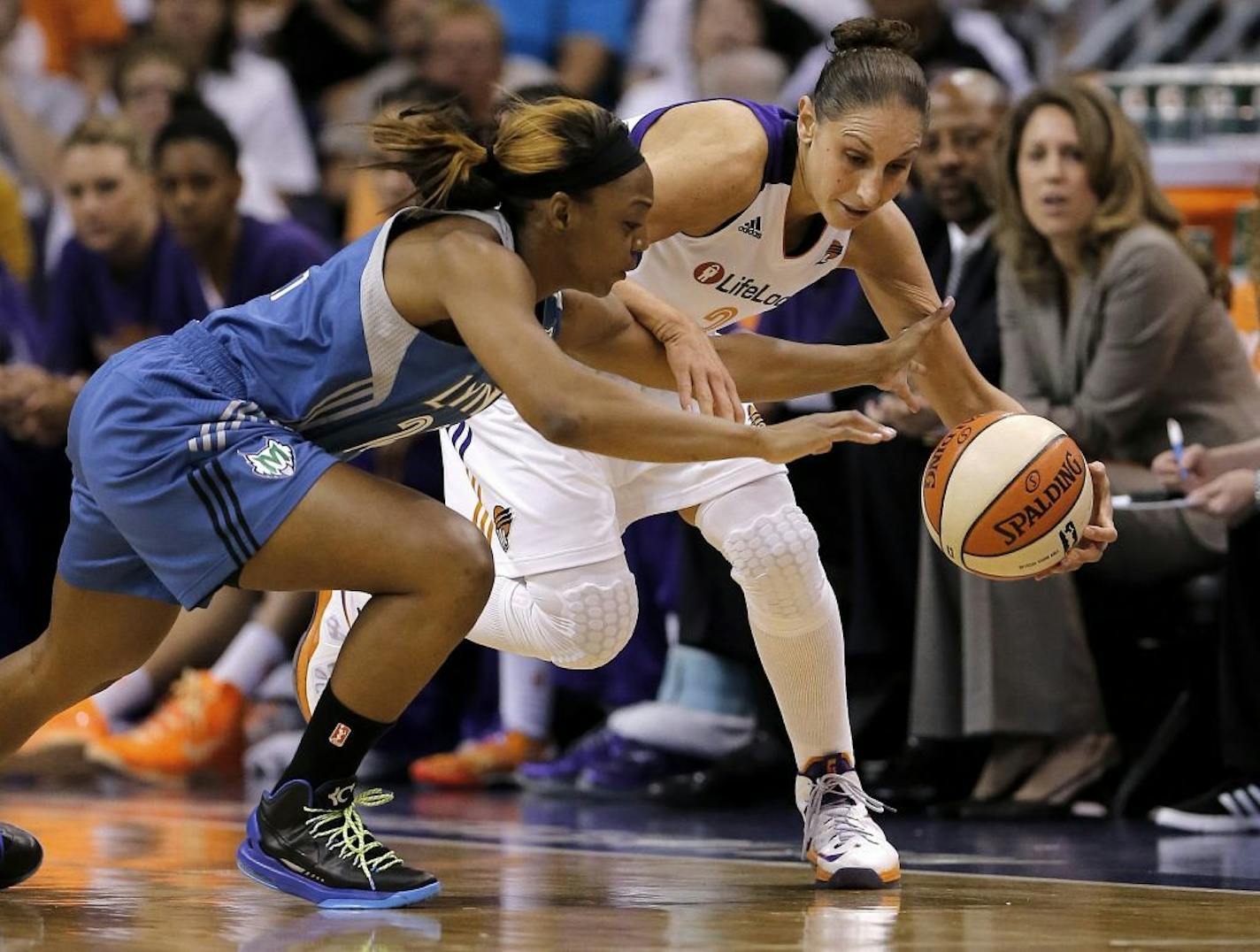 Minnesota Lynx guard Monica Wright, left, knocks the ball loose from Phoenix Mercury guard Diana Taurasi during the first half of a WNBA basketball game, Wednesday, June 19, 2013, in Phoenix.