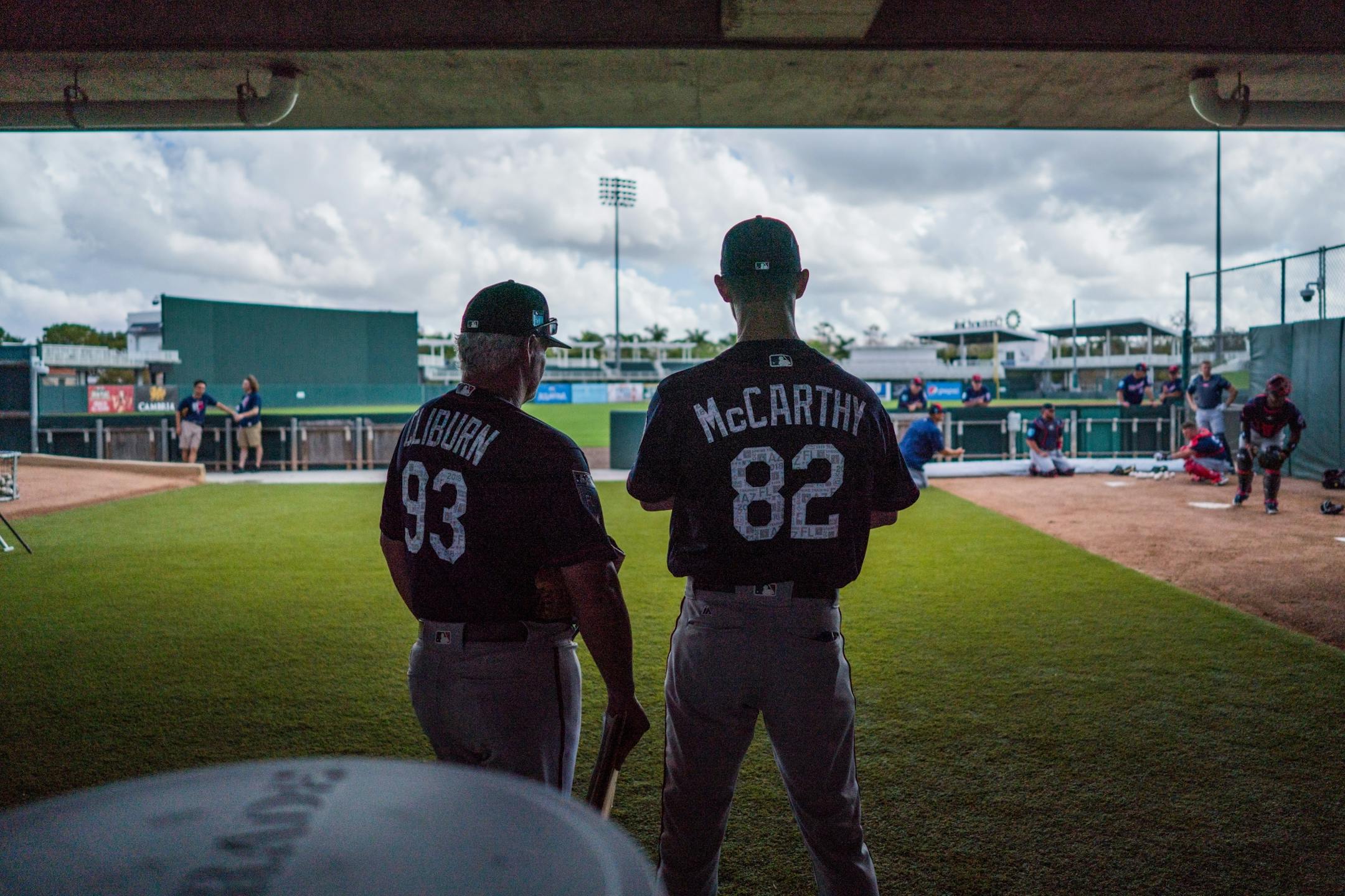 Twins AAA pitching coach Stu Cliburn and AAA bullpen coach Mike McCarthy watch catchers' workouts.