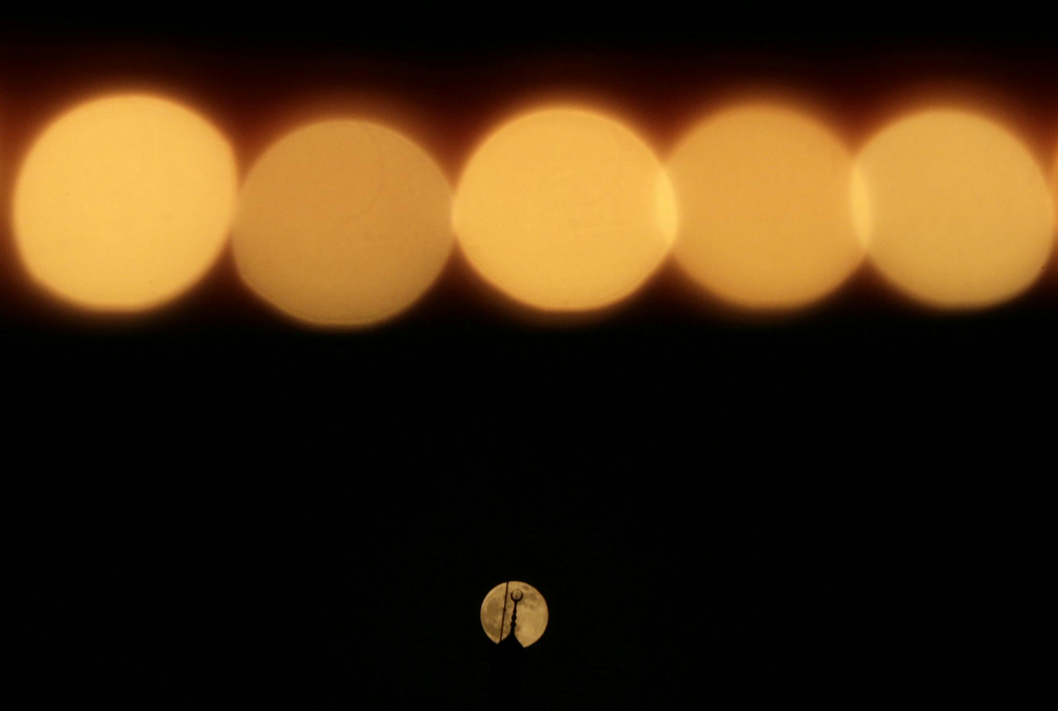 A Supermoon rises through a clear sky past a string of yellow lights, in Cairo, Egypt, Sunday, June 23, 2013. The moon, which will reach its full stage on Sunday, is expected to be 13.5 percent closer to earth during a phenomenon known as supermoon. The "Supermoon" happens only once this year as the moon on its elliptical orbit is at its closest point to earth. (AP Photo/Hassan Ammar)
