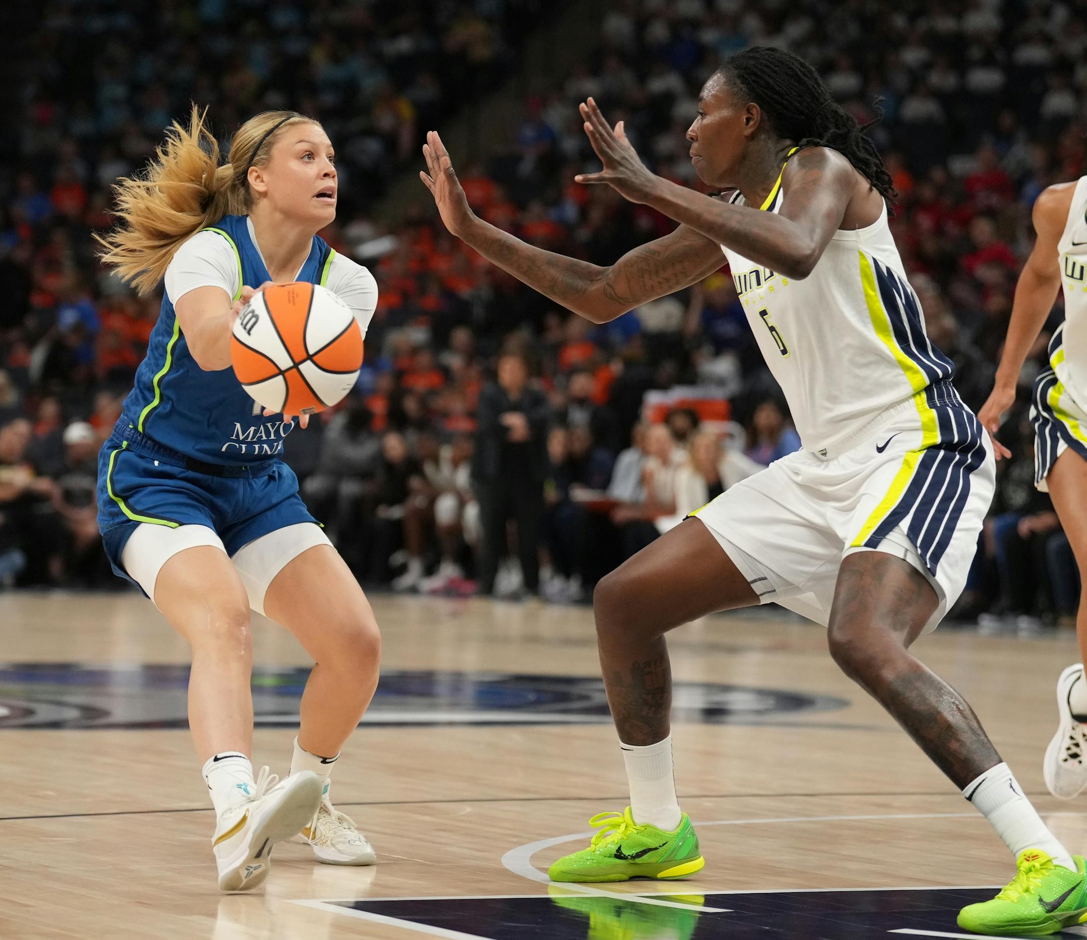 Minnesota Lynx guard Rachel Banham (15) drives the lane while she's defended by Dallas Wings forward Natasha Howard (6) in the first half.