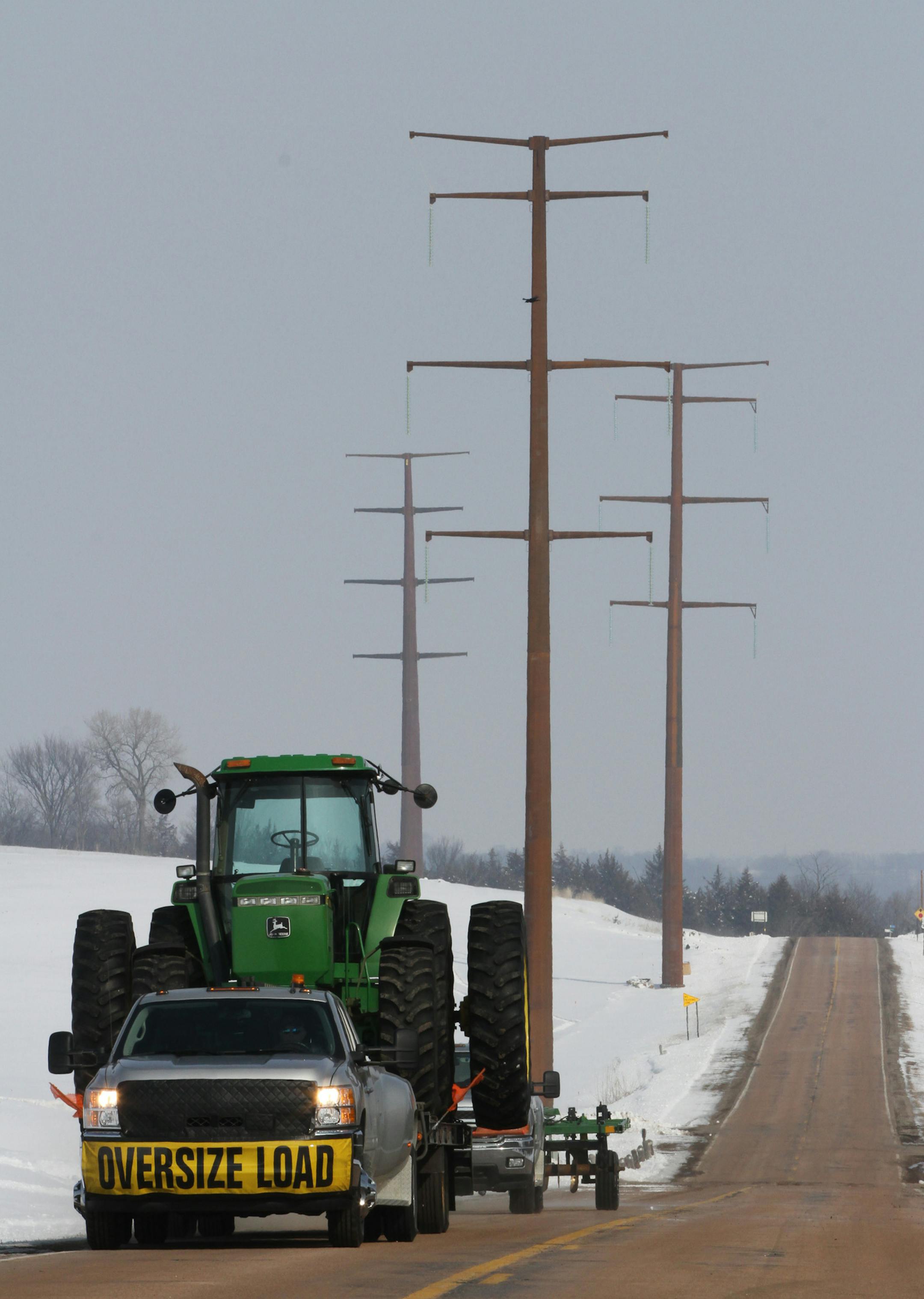 One of the last pieces of farm machinery auctioned off by Wayne Koepp was transported off his Belle Plaine cattle farm after selling his farm to brother Mark Koepp. Behind the transport truck were the new power line towers being constructed. Mark Koepp, a hog farmer outside of Belle Plaine, is one of several affected landowners with concerns about the new line being built on his land. Crews have erected five towers on his 134-acre farm, and another seven on nearby land he rents. Construction cre