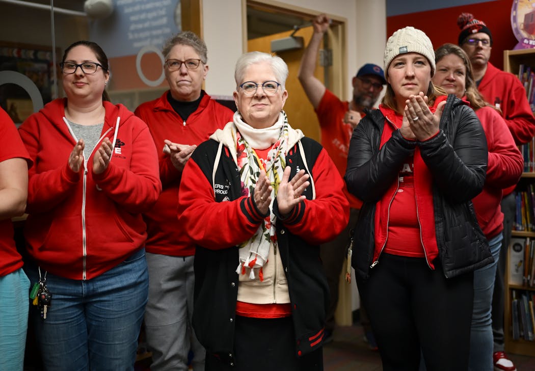 Members of the Saint Paul Federation of Educators bargaining team, including Rene Myers, center, and Davia Christiansen, right, celebrated their tentative agreement during a press conference Tuesday at Maxfield Elementary in St. Paul. 