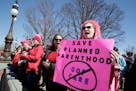 An activist protests cutting funds for Planned Parenthood in March in Washington, D.C.