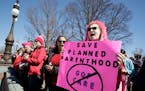 An activist protests cutting funds for Planned Parenthood in March in Washington, D.C.