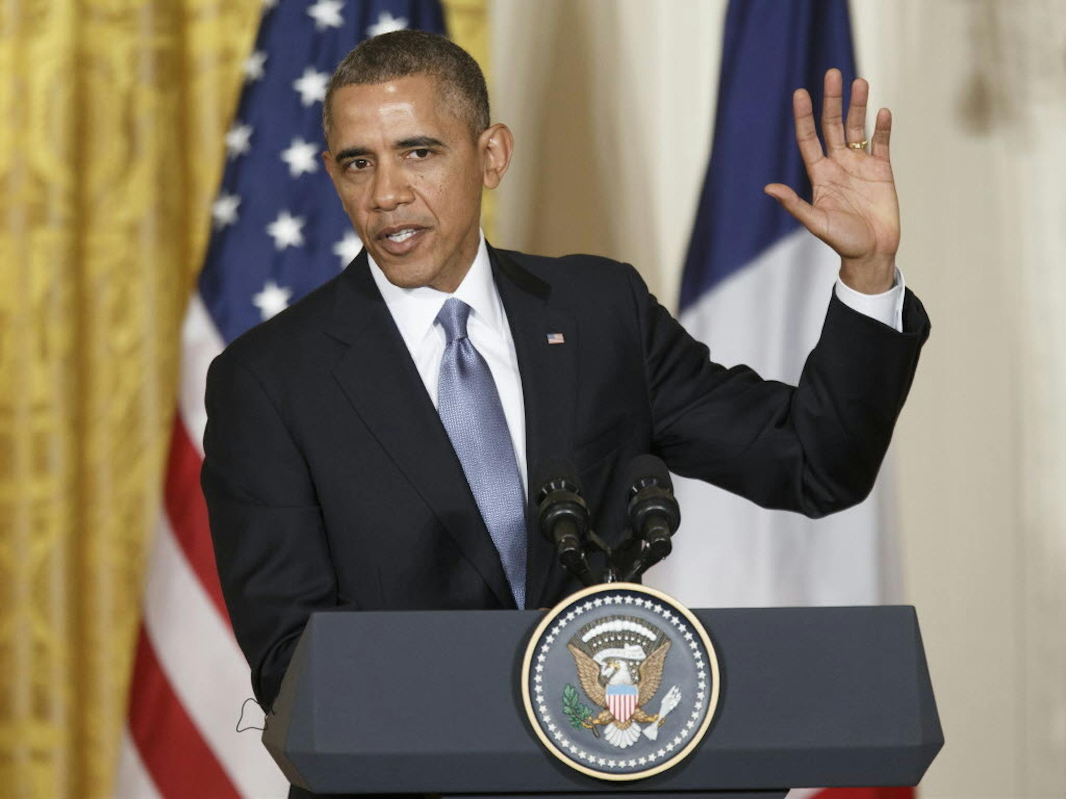 President Barack Obama answers a question as he and French President Francois Hollande face reporters during a joint news conference in the East Room of the White House in Washington, Tuesday, Feb. 11, 2014.