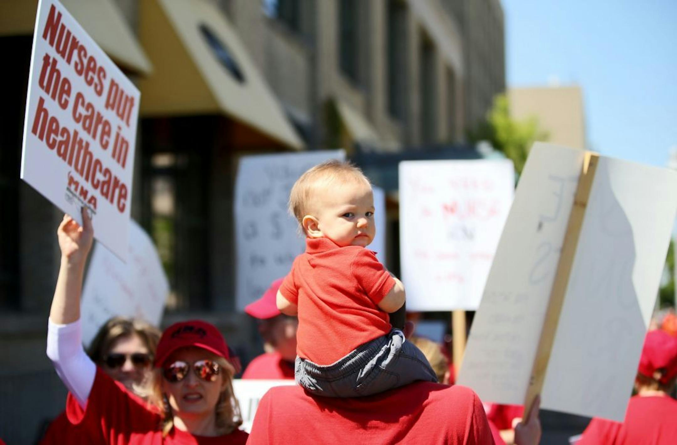 Nurses with Allina Health held an informational picket on May 18, 2016, as talks between their union and health system leaders have broken down over health insurance. Here, Here, Nolan Waits, 10 months, sat atop the shoulders of his RN dad Bryan Waits of Lakeville, who works in the ICU at Abbott Northwestern Hospital and was seen picketing outside the Allina Commons at the Global Market Wednesday, May 18, 2016, in Minneapolis, MN.(DAVID JOLES/STARTRIBUNE)djoles@startribune Nurses with Allina Hea