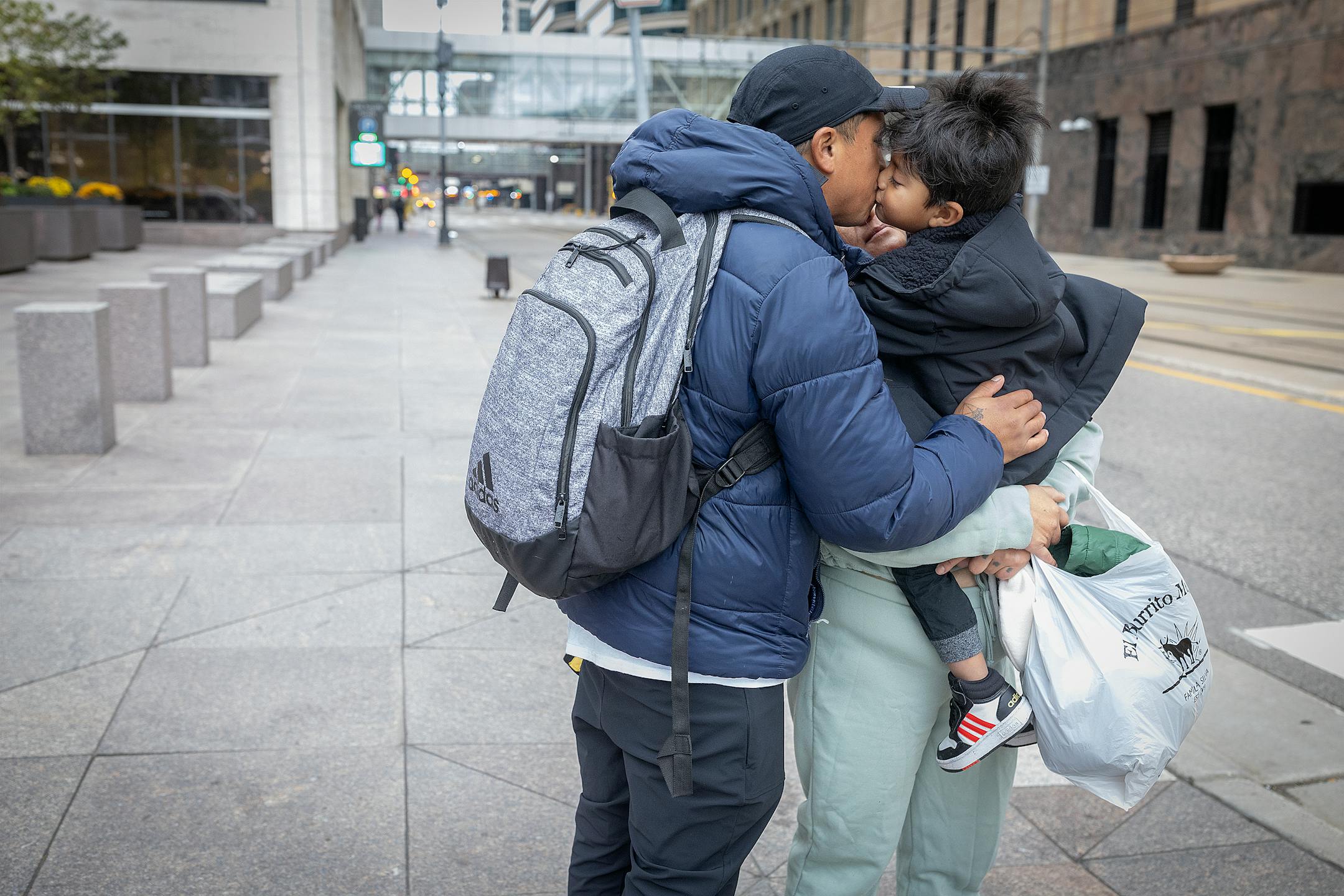 Jhon says goodbye to his wife Sara and their 3-year-old son after a family visit near their family shelter.