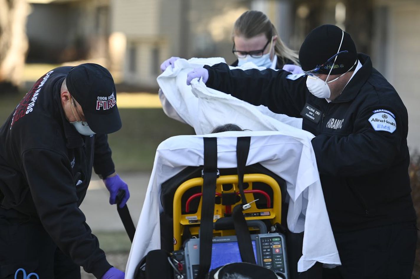 Coon Rapids firefighter Darin Jahnke and Allina Health paramedics Kelsey Cook and Dan Lennartson helped a woman having a suspected COVID-19 medical emergency Wednesday in the northern metro area.