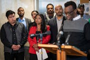 City Council members listen to Eid Ali, president of MULDA, speak at a news conference Thursday.