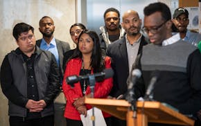 City Council members listen to Eid Ali, president of MULDA, speak at a news conference Thursday.