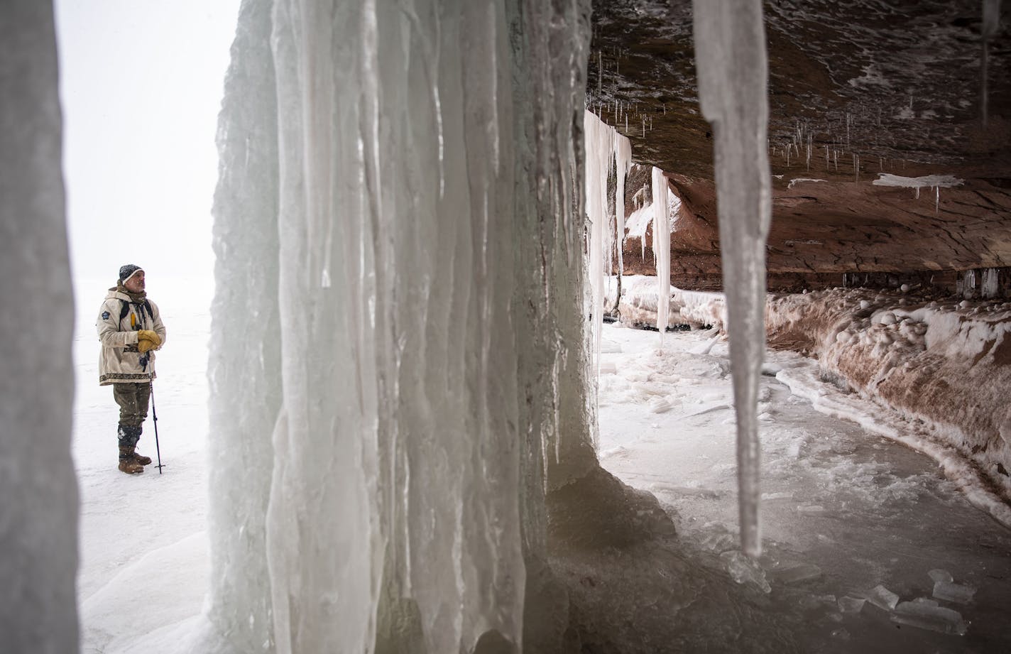 Jon Michels, one of the two guides for the Red Cliff Point guided ice cave tour, admired the large icicles on the ice formation nicknamed "big blue" on Wednesday February 26, 2020. It is considered the most impressive of the formations on Red Cliff Point. . ]
ALEX KORMANN &#x2022; alex.kormann@startribune.com While not being the famed Apostle Islands National Lakeshore ice caves, the new ice formations on the south shore of Lake Superior near Bayfield, WI are still drawing interest. Jon Michaels