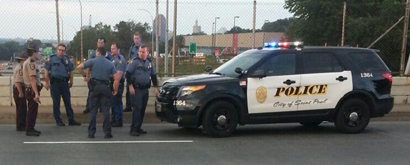 Officers convene on the Dale Street bridge over I-94 in St. Paul, after a group of civilians helped police officers pull a suicidal woman to safety. Photo: Lucky Rosenbloom