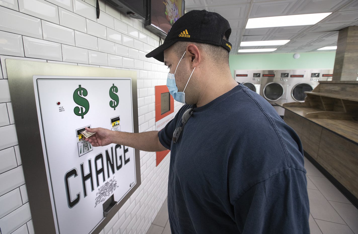 Adrian Aguilar gets change in quarters from a $5 bill at SpinCycle Laundry Lounge in Los Angeles, before feeding them into the washing machine and dryer to do his laundry. There is a nationwide coin shortage and laundromats have been particularly affected since customers might not always walk in with enough quarters to do their laundry. (Mel Melcon/Los Angeles Times/TNS) ORG XMIT: 1729928