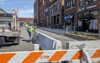 Spencer Stepan of St. Cloud Public Works installs a concrete barrier on Fifth Avenue in downtown St. Cloud. Enclosed in the barrier will be additional