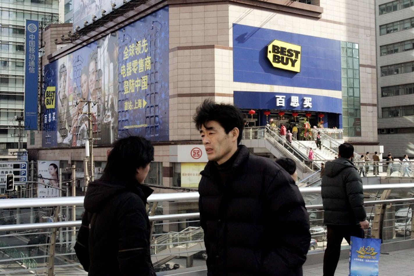 FILE -- Pedestrians walk past Best Buy's store in Shanghai, China, on Dec. 28, 2006.